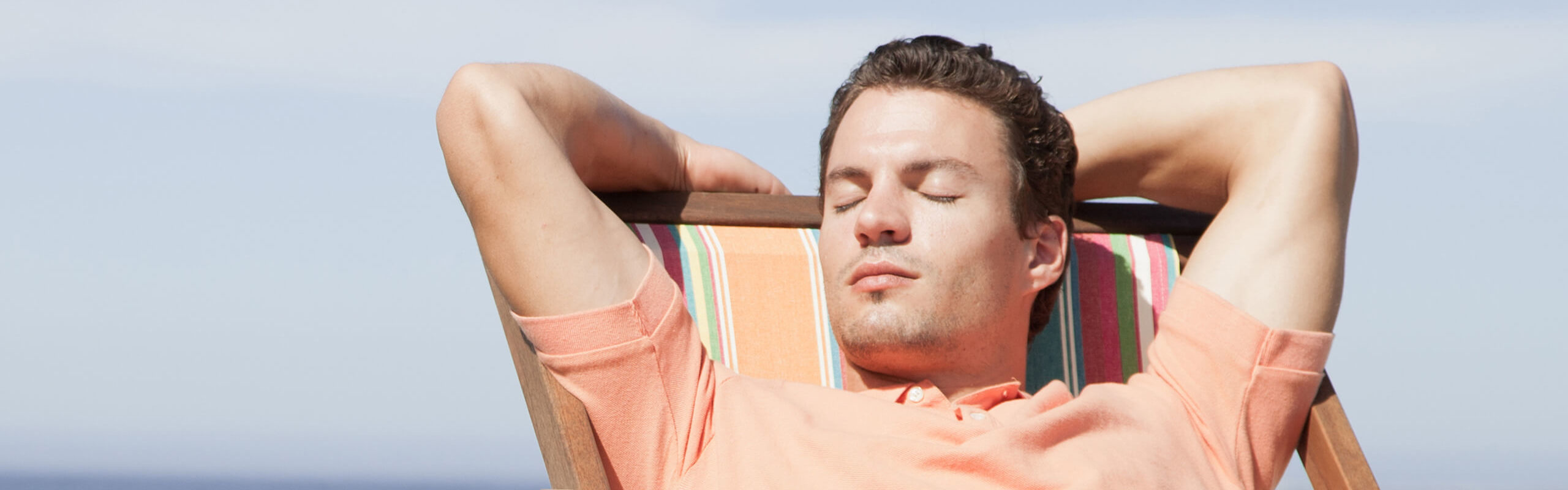 man relaxing with eyes closed in a beach chair