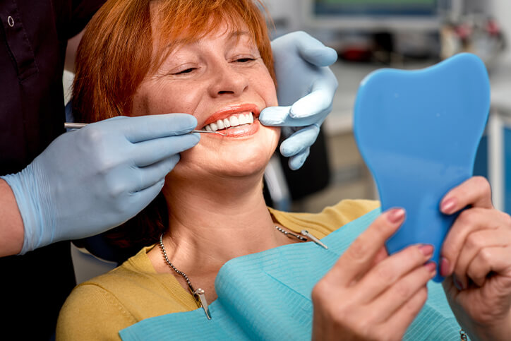 older woman smiling in dentist's chair