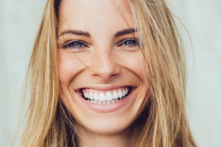 A young woman smiling after she received veneers