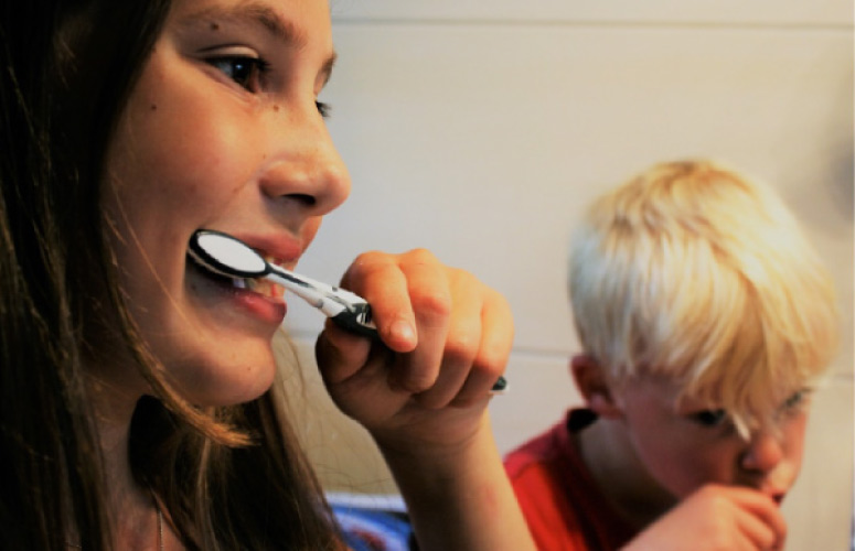 young boy and girl brushing their teeth