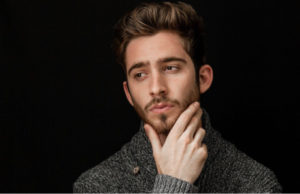 man holding his chin pondering the best type of dental implant for him